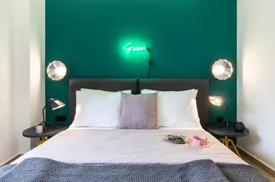 a bedroom with a bed with a green sign on the wall at 14 Reasons Why Hotel Athens in Athens