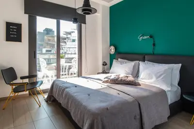 a bedroom with a large bed with a green wall at 14 Reasons Why Hotel Athens in Athens
