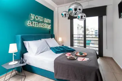 a bedroom with a bed with a blue wall at 14 Reasons Why Hotel Athens in Athens