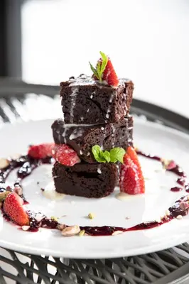 a stack of chocolate cake with strawberries on a plate at 14 Reasons Why Hotel Athens in Athens