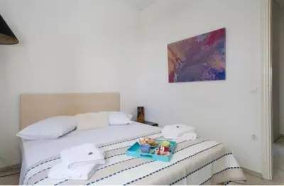 a white bed with a tray of toys on it at At Trendy Glyfada's Center in Athens