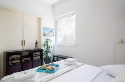 a bedroom with a bed with a tray of food on it at At Trendy Glyfada's Center in Athens