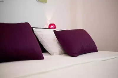 two purple pillows sitting on top of a bed at At Trendy Glyfada's Center in Athens