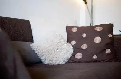 a couch with two brown pillows and a white pillow at At Trendy Glyfada's Center in Athens
