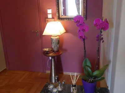 a lamp on a table with purple walls and flowers at Athens-Plaka, Peter’s beautiful apartment in Temple of Zeus in Athens