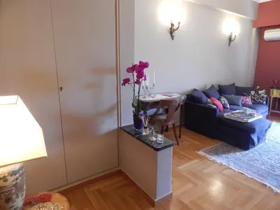 a living room with a couch and a table with flowers on it at Athens-Plaka, Peter’s beautiful apartment in Temple of Zeus in Athens