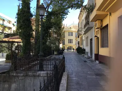 an empty street with a lamp post and buildings at Athens-Plaka, Peter’s beautiful apartment in Temple of Zeus in Athens