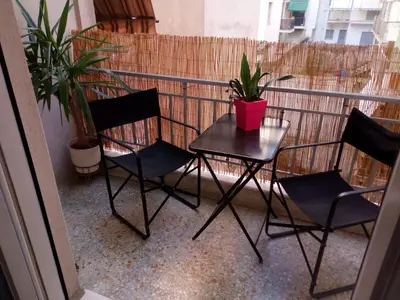 a table and chairs on a balcony with plants at Aristotle's studio apartment in Athens