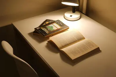 an open book on a table with a lamp and a picture at Aristotle's studio apartment in Athens