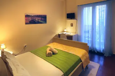 a bedroom with a bed with a green and yellow blanket at Aristotle's studio apartment in Athens