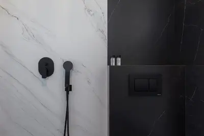 a shower with a black and white wall at Athenian Lofts in Athens