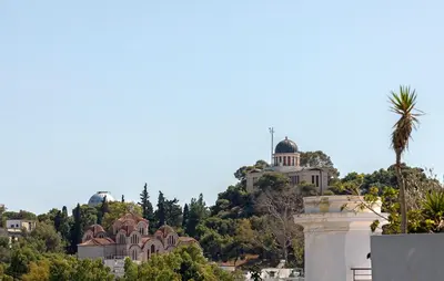 a view of a hill with houses and a palm tree at Athenian Lofts in Athens