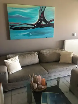 a living room with a couch and a painting on the wall at Villa Sophia in Porto Rafti