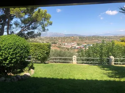 a view of a yard with a fence and green grass at Villa Sophia in Porto Rafti