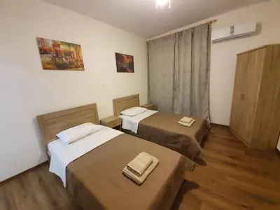 two beds in a small room with wooden floors at City Centre Stylish rooms in Athens