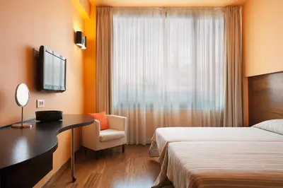 a hotel room with a bed and a desk and a window at Athens Center Square Hotel in Athens