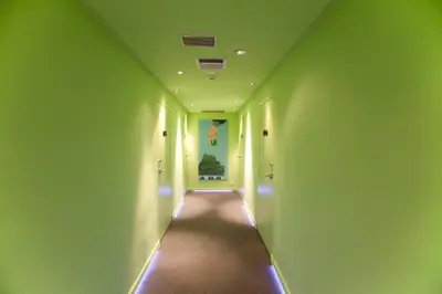 a hallway with green walls and a long corridor at Athens Center Square Hotel in Athens