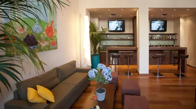 a living room with a couch and a bar at Athens Center Square Hotel in Athens