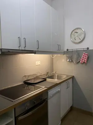 a kitchen with a sink and a clock on the wall at Ermou 44 - 3bdr Apartment in Athens