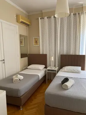 two twin beds in a room with two tables at Ermou 44 - 3bdr Apartment in Athens