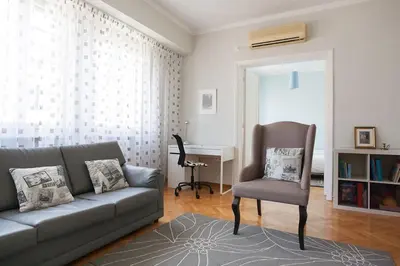 a living room with a couch and a chair and a desk at Ermou 44 - 3bdr Apartment in Athens