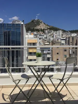 a table and chairs on a balcony with a city at Homz AH02 Kolonaki Penthouse Studio in Athens