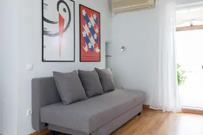 a couch in a living room with paintings on the wall at Homz AH02 Kolonaki Penthouse Studio in Athens