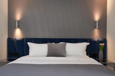 a bed with a blue headboard and white pillows at Athens4 in Athens