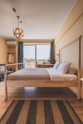 a bedroom with a large bed with a large window at Acropolis View - Living Stone Sapphire Apartment in Athens