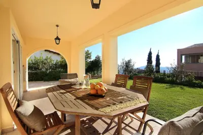 a table with a bowl of fruit on a patio at Villa Domus Riviera in Athens