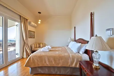 a bedroom with a bed with a view of the ocean at Villa Domus Riviera in Athens