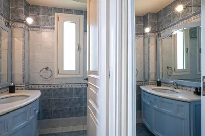 a bathroom with two sinks and two mirrors at Villa Domus Riviera in Athens