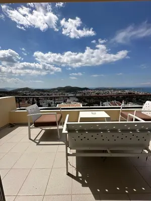a balcony with tables and chairs on a roof at Villa Domus Riviera in Athens