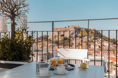 a table with a plate of food and a view of the city at Urban Frame Plaka in Athens