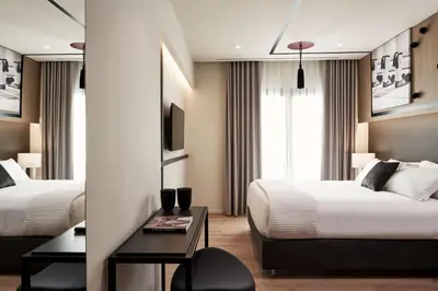 a hotel room with two beds and a table at Urban Frame Plaka in Athens