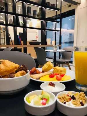 a table with plates of food and a glass of orange juice at Urban Frame Plaka in Athens