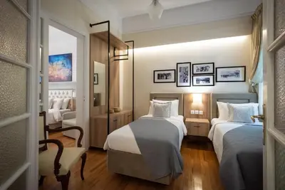 a hotel room with two beds and a chair at Blue Ark Lavish Sauna Suite in Athens