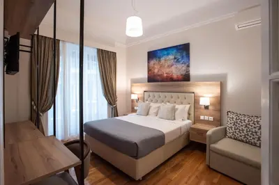 a hotel room with a bed and a chair at Blue Ark Lavish Sauna Suite in Athens