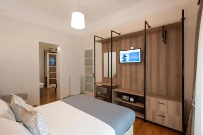 a bedroom with a bed and a tv on a wall at Blue Ark Lavish Sauna Suite in Athens