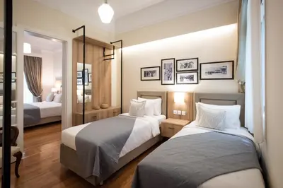 a hotel room with two beds and a mirror at Blue Ark Lavish Sauna Suite in Athens