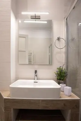 a bathroom with a white sink and a mirror at Blue Ark Lavish Sauna Suite in Athens