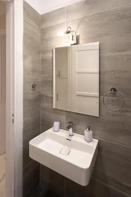 a bathroom with a white sink and a mirror at Blue Ark Lavish Sauna Suite in Athens