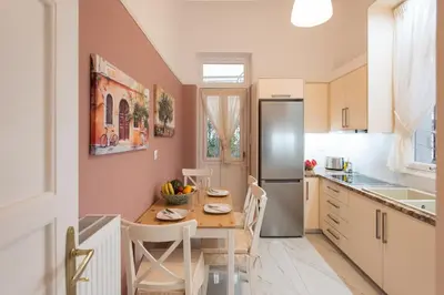 a kitchen with a table and a refrigerator at Blue Ark Lavish Sauna Suite in Athens