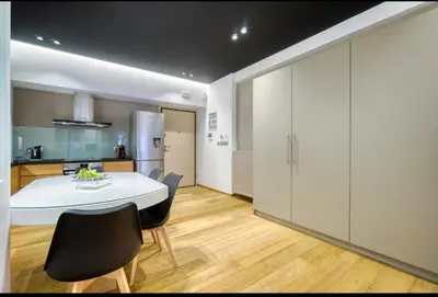 a kitchen and dining room with a white table and chairs at Zolie Apartment in Athens