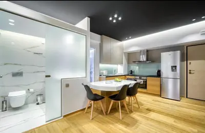 a kitchen with a table and chairs in a room at Zolie Apartment in Athens