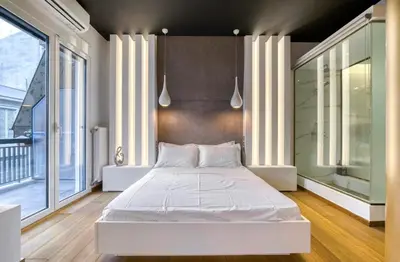 a large white bed in a room with large windows at Zolie Apartment in Athens