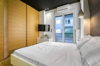 a bedroom with a large white bed and a window at Zolie Apartment in Athens