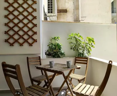 a wooden table and chairs on a patio at KYMA Apartments - Athens Acropolis 21 in Athens