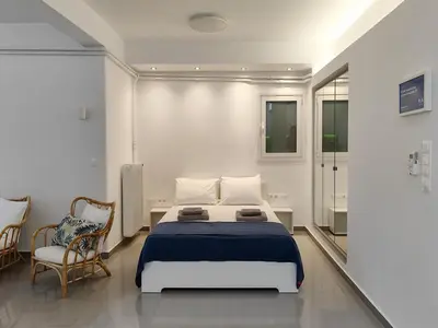 a bedroom with a bed and a chair at KYMA Apartments - Athens Acropolis 21 in Athens