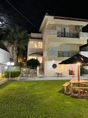 a house with a picnic table and an umbrella at Blue Sky on the Sea Appartments in Athens